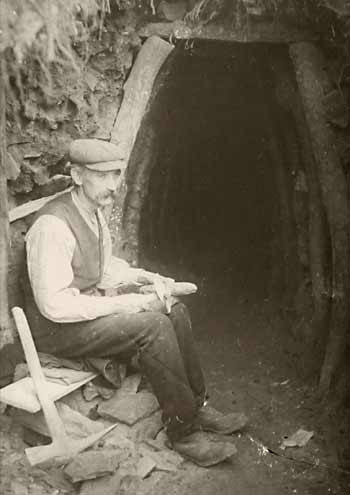 old photo of a whetstone miner outside his mine