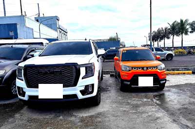A huge SUV parked next to a sensibly sized vehicle.