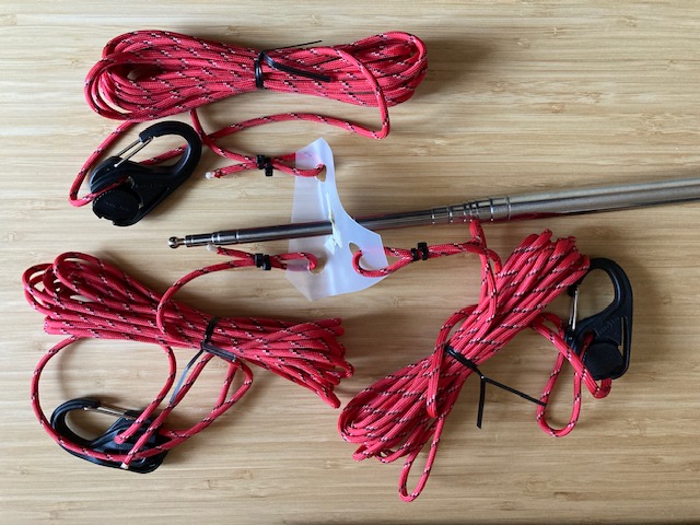 Photo 1 of the DIY Universal Guy System showing three guy sets and a center section to go over the SS-17 whip, made out of gallon water jug plastic with a 3/8" metal grommet center.