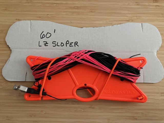DIY 60 foot sloper black antenna wire with orange guy lines, all wound on a plastic wire winder.