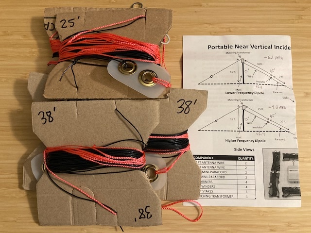 Photo of DIY NVIS crossed dipole set, with black antenna wires and orange end guy lines wound onto homemade cardboard wire winders.
