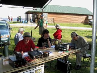 Dave, KV4CN, and John, K4KBB, tuning the radios.  Others in the picture, David, W4DWA, at the table and in the background from left, Taylor, W4WTM, Murray, K4MHM, and Dave Mumau 