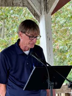 A person standing next to a table with a table and chairs

Description automatically generated